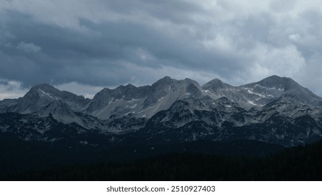 Panorama of the snow capped mountain peaks of Triglav National Park, Slovenia, under the stormy sky. - Powered by Shutterstock