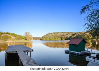 Panorama of Sotsko Jezero, or lake Sot, in Fruska Gora, in Serbia, Europe, in summer, at dusk, with a holiday cabin and a pontoon over the water. it is a major natural landmark of Vojvodina. 