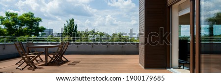 Panorama of spacious terrace with wooden floor and furniture, and amazing view