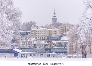 Panorama of St. Michael  Church and surrounding architecture in Belgrade, Serbia, from the riverbank, during very cold, winter, foggy day. This bell tower and building are one of national landmarks