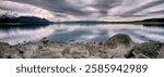 Panorama of a still Lake Tekapo with interesting cloud cover