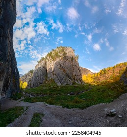 Panorama of a stone tract in the Altai mountains with a large smooth rock among the forest during the day. The site of an ancient man. A small figure of a tourist sitting on the edge - Shutterstock ID 2258404945