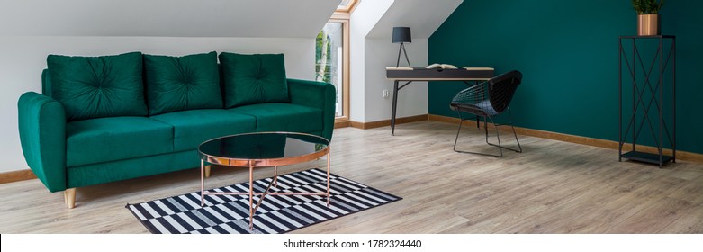 Panorama Of Stylish Attic Living Room With Emerald Green Wall And Sofa And Home Office Corner