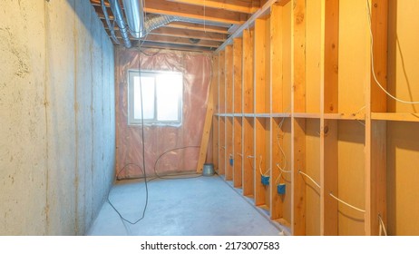 Panorama Sun Flare Unfinished Food Storage Room At The Basement With Window. Empty Basement Interior With Wood Frames And Panel On The Left Across The Concrete Wall On The Right.