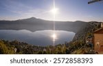 Panorama of a sunrise lighting up the hillside villas around Lake Albano in Castel Gandoldo Italy. 