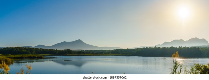 Panorama of the sunrise in the morning with mountain, lake and sky at Mae Mo, Lampang, Thailand.