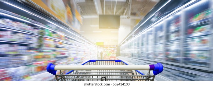 Panorama. Supermarket aisle with empty blue shopping cart