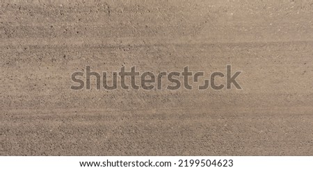 panorama of surface from above of gravel road with car tire tracks