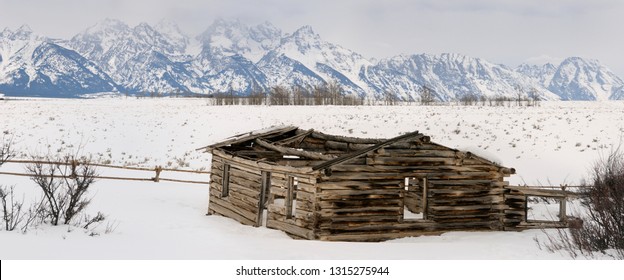 Panorama of the Teton Range mountains in Wyoming with collapsed Shane Cabin in winter