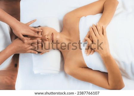 Panorama top view of woman enjoying relaxing anti-stress head massage and pampering facial beauty skin recreation leisure in dayspa modern light ambient at luxury resort or hotel spa salon. Quiescent