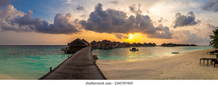 Panorama of Tropical sunset over bungalows at Tropical beach in the Maldives at summer evening