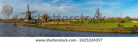 Panorama of typical dutch rural landscape with traditional windmill and the river Gein in the town of Abcoude