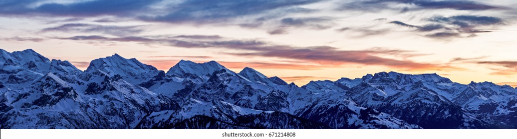 Panorama of vibrant winter sunset over the Swiss Alps near Interlaken in Switzerland. - Shutterstock ID 671214808
