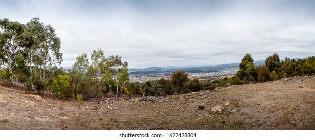 Panorama View Of An Australian Bush Clearing, Featuring Distant Rolling Hills And Patchy Woodlands. Foreground Area Was Recently Destroyed To Make Way For Urban Development. Storm Clouds Approaching.