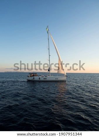 Panorama view of boat sailboat ship sailing into sunset mediterranean sea ocean water Mallorca Balearic Islands Spain