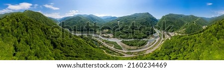 Panorama view: Cable-Stayed Bridge on the Adler-Krasnaya Polyana motorway. Aerial view of car driving along the winding mountain road in Sochi, Russia.