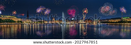 Panorama view of citycenter from Alster Lake,view to Hamburg Rathaus and fountain in the center of the lake with fireworks. Festive atmosphere with fireworks in Hamburg. Port birthday in Hamburg.