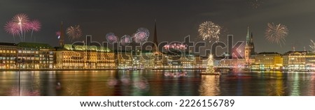 Panorama view of citycenter from Alster Lake,view to Hamburg Rathaus and fountain in the center of the lake with fireworks. Festive atmosphere with fireworks in Hamburg. Silvester in Hamburg.