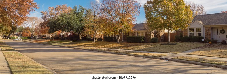 Panorama view clean sidewalk and quite residential street with row of single family house and colorful fall foliage near Dallas, Texas, America. Sunny cloud blue sky in a beautiful autumn day