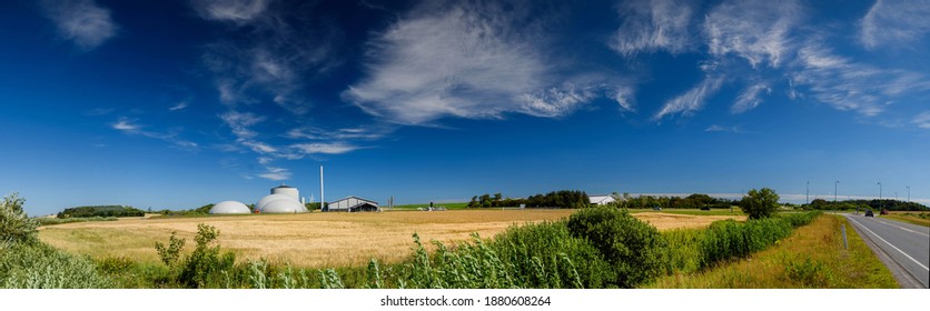 Panorama view of countryside in North Jutland with biogas plant, Denmark.Cornfield with agricultural factory in the background in the countryside.