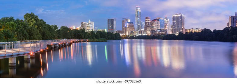 Panorama view of Downtown Austin, Texas, USA skylines reflection on the Colorado River at twilight. View from Ann and Roy Butler Hike-and-Bike Trail and boardwalk at Lady Bird Lake is on the left.