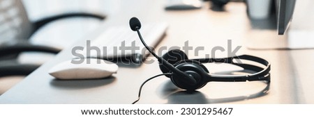 Panorama view of empty call center operator workspace, focused on headset. Representing corporate customer service support and telesales communication technology. Prodigy