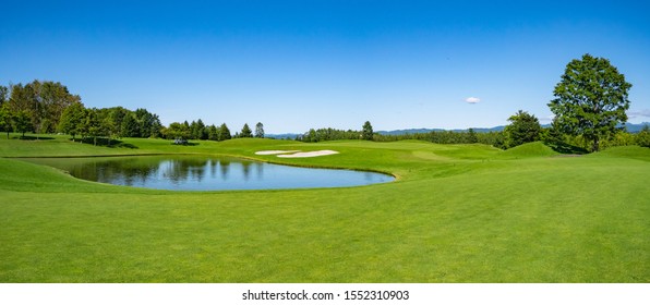 Панорамный вид на поле для гольфа с красивым зеленым полем. Поле для гольфа с богатым зеленым газоном и красивыми пейзажами.