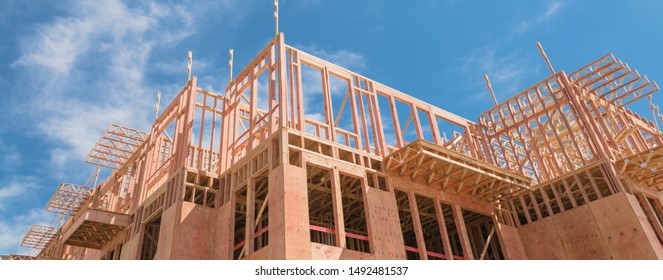 Panorama view low angle view of modern condominium building with large patio under construction near North Dallas, Texas. Wooden house with timber framing, truss, joist, beam close-up cloud blue sky