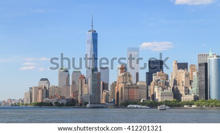 Panorama view of Manhattan, New York City with blue sky and slightly cloud. Battery park on the edge of the shore which surround by many tall building in business area.