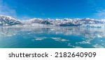 A panorama view past floating ice in Disenchartment Bay towards in the Valerie and Hubbard Glacier, Alaska in summertime
