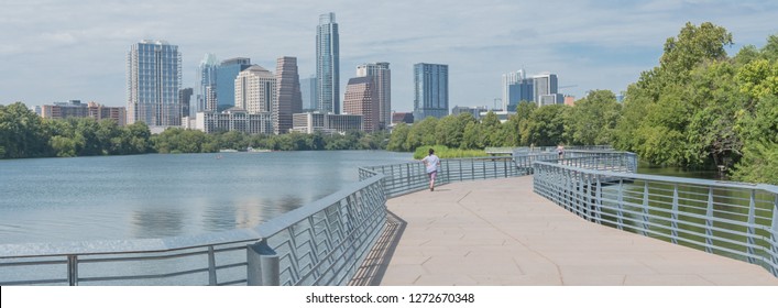 Panorama view people biking running walking along boardwalk near downtown Austin, Texas in summer day