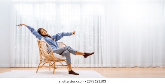 Panorama View Shot of Young Asian Woman Relaxing in Modern Wicker Chair Near Window with Sheer Curtain, Happy Female Using Mobile Smartphone Enjoying at Home, Comfort and Cozy - Powered by Shutterstock