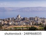 The panorama view of Tiberias, the Israeli city on the Sea of Galilee, with modern houses, the Lake, and the Golan Heights, in Israel.
