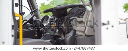 Panorama view two steering wheels for dual control on modern four wheel mechanical broom sweeper truck, cabin complete with fully dualized operate from closest street curb side optimize sweeping. USA