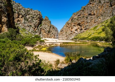 Vue panoramique d'une vallée avec étang à l'intérieur de la gorge profonde avec berge fluviale du torrent de Pareis et de la plage de Cala de Sa Calobra en arrière-plan du village de Sa Calobra à Majorque.