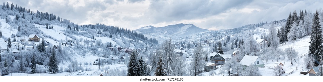 Panorama of the village in the winter mountains covered with snow. Winter landscape. The concept of freedom and solitude.