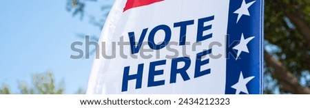 Panorama Vote Here high resolution text on political vote flag banner fiberglass poles, polyester double-sided election decorations polling locations on rotating pole, non-English-proficient, TX. USA