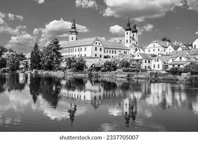 Panorama of Telč with water reflections on the lake in Telč, Czech Republic in black and white