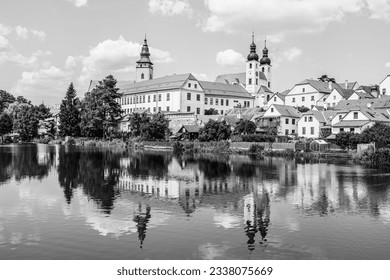 Panorama of Telč with water reflections on the lake in Telč, Czech Republic in black and white
