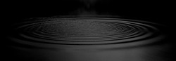 Panorama Wasser Reißt Aus Einem Wassertropfen Im Dunkeln. Wassertropfen Dunkler Ton. Abstrakter, Schwarzer Kreis Wassertropfen. Flüssige Textur Hintergrund.Flüssige Flüssigkeit Mit Stimmungseffekt In Schwarz-Weiß.