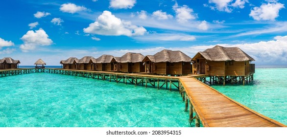 Panorama of  Water Villas (Bungalows) and wooden jetty at Tropical beach in the Maldives at summer day