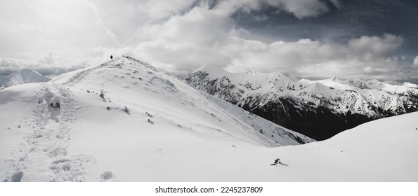 Panorama of the Western Tatra Mountains in the winter aura. Winter holidays in the Polish mountains. Tatra Mountains. Mountain hiking in crampons and with an axe.