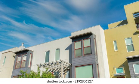 Panorama Whispy White Clouds Low Angle View Of Colorful Complex Buildings At Daybreak In South Jordan, Utah. Building Exterior With Gray Window Bays Exterior And A Green Wall On The Left