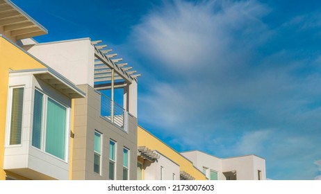 Panorama Whispy White Clouds Row Of Apartment Buildings With Rooftops And Pergola At Daybreak In South Jordan, Utah. Building Exterior With Yellow, White And Gray Walls.