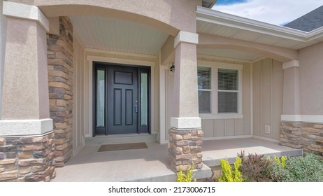 Panorama white clouds Facade of a front exterior of a house with front yard garden. Porch with black front door with lockbox and two side panels near the windows and a wall with wooden and stone - Shutterstock ID 2173006715