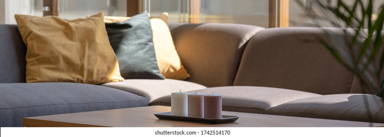Panorama of wooden coffee table and gray corner sofa in living room with window wall - Shutterstock ID 1742514170