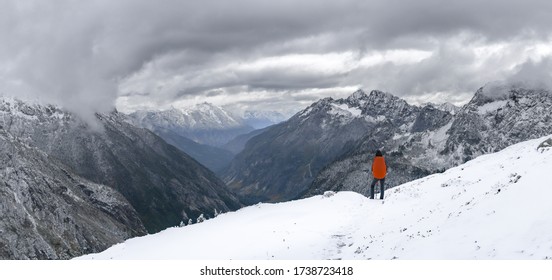 Panorama Of Young Woman Carrying Orange Backpack Stands And Admires The View, She Is On The Way To Sahale Glacier Camp, North Cascades National Park, WA, USA. Concept Of Solo Female Traveler.