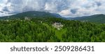 Panoramic aerial perspective of spectacular Peles Castle situated in Sinaia, Romania. Neo-Renaissance castle in the Carpathian Mountains surrounded by forest. Constructed for King Carol I. Travel. 