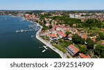 Panoramic aerial photo from drone to Mikolajki townscape - capital of Masurian region on the shore of the holiday resort beautiful summer afternoon. Mikolajki, Mikołajki, Poland, Europe.