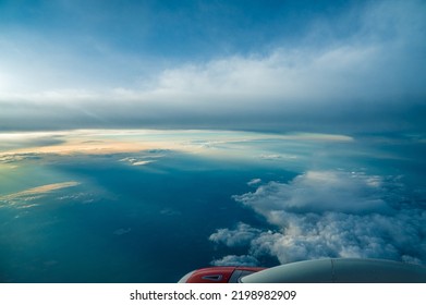 Panoramic aerial view. Beautiful sunset sky above clouds with dramatic light. Cabin view from airplane. Passenger airliner. Business trip. Commercial aircraft